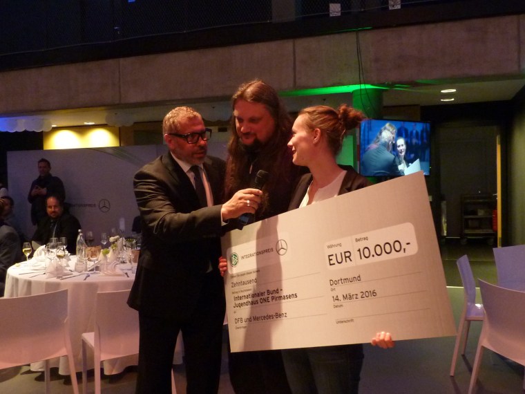 DFB-Integrationsbeauftragter Jimmy Hartwig bei der Scheckübergabe an das Jugendhaus ONE Pirmasens